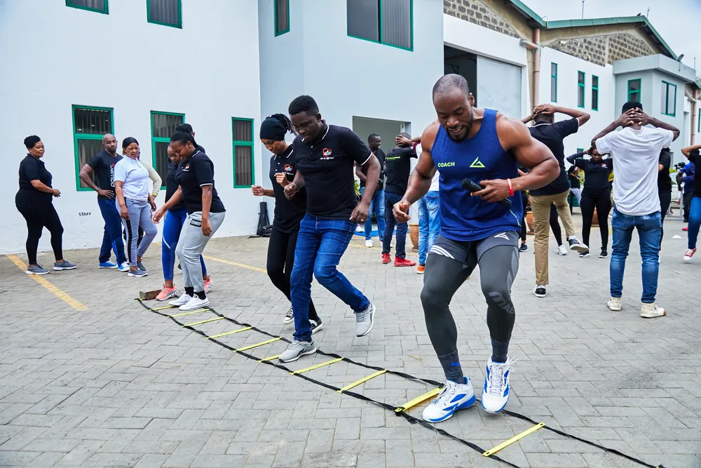 A Body Justice Fitness coach guiding a group through an outdoor team workout
